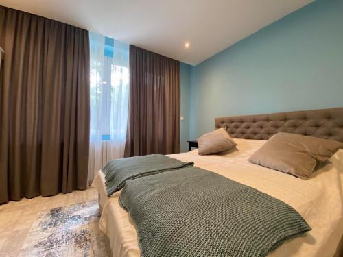 a bedroom with a large bed in front of a window at Apartman Teatar in Sombor