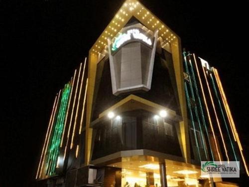 a tall building with lights on it at night at Hotel Shree Vatika in Bhopal