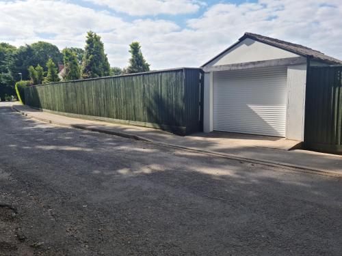 a fence with a garage on the side of a road at HALLSTEAD in Skegness