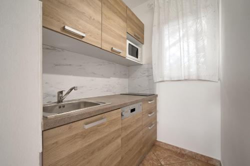 a kitchen with wooden cabinets and a sink at Holiday Park Mandrice in Mandre