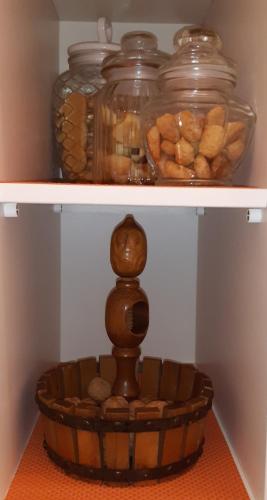 a wooden bowl on a shelf with jars of peanuts at Pietra d'angolo in Locorotondo