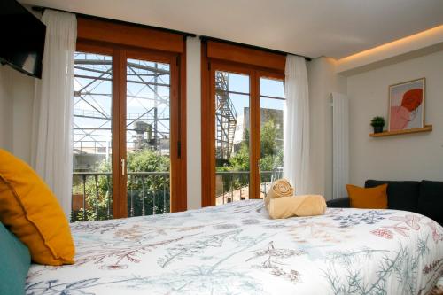 a bedroom with a bed and a large window at Loft " La fábrica de Gas",PARKING in Oviedo