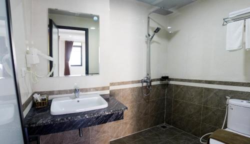 uma casa de banho com um lavatório, um espelho e um WC. em Sunrise Motel em Ha Long