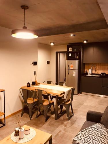Una cocina y un comedor con mesa y sillas. en AIKEN con cochera PB, en San Martín de los Andes