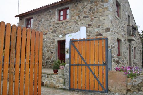 a wooden gate in front of a stone house at Casa de l Puio in Picote