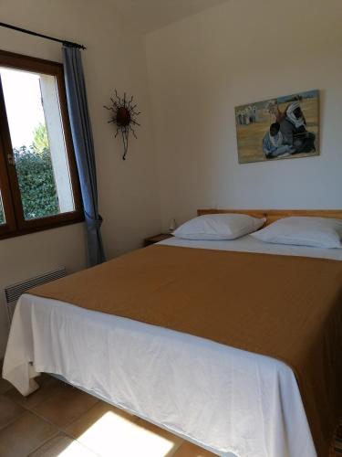 une chambre avec un grand lit avec une fenêtre dans l'établissement Gîte Les Romarins Vue exceptionnelle !, à Saint-Jean-de-Minervois
