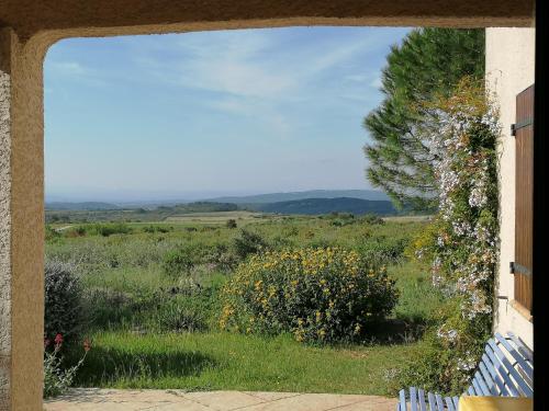 a view of a field through a window at Gîte Les Romarins in Saint-Jean-de-Minervois