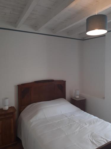 een slaapkamer met een wit bed en 2 nachtkastjes bij la maison des vendangeurs in Villesequelande