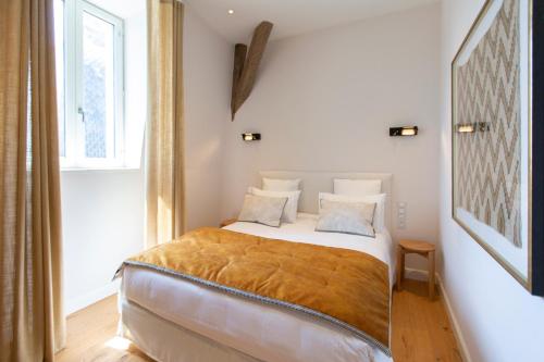 a bedroom with a bed with a gold blanket on it at Hôtel Le Mosaïque in Narbonne