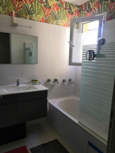 une salle de bain avec une baignoire, un lavabo et un miroir dans l'établissement VILLA VAI avec piscine, à Vaison-la-Romaine