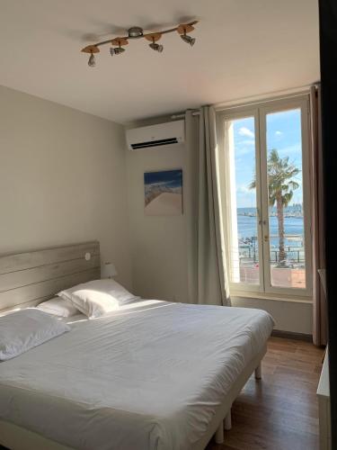 une chambre avec un lit avec vue sur la plage dans l'établissement Hotel-Restaurant Du Port, à Mèze