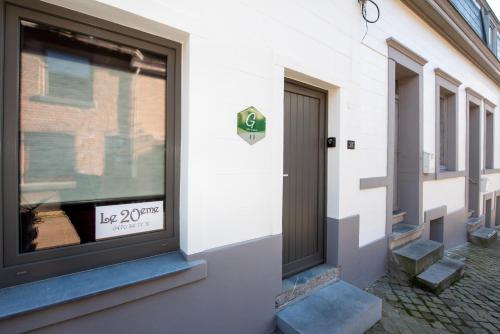 a front door of a building with a sign in a window at gîte le vingtieme in Spa