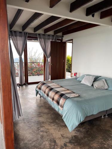 a bedroom with a bed and a large window at El Filito in San JosÃ©