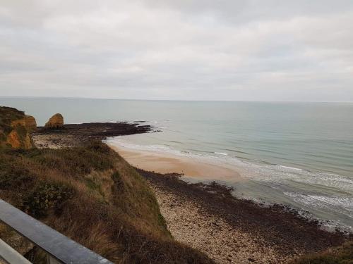 a view of a beach with the ocean at le bonheur des plumes in Montmartin-en-Graignes