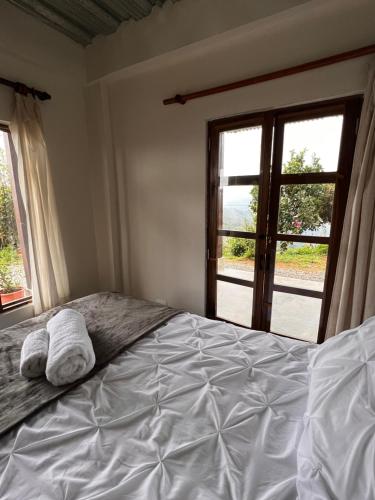 a bedroom with a bed with two towels on it at El Filito in San JosÃ©