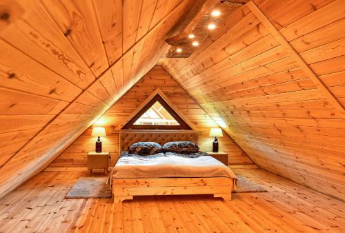 1 dormitorio en una cabaña de madera con 1 cama. en Agroturystyka Pod Czernicą, en Stronie Śląskie