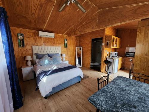 Standerton的住宿－The Log Cabin Apartments Hotel，卧室配有一张床铺,位于带木墙的房间内