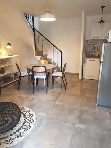 d'une salle à manger avec une table, des chaises et un réfrigérateur. dans l'établissement Charmant 2 pièces en plein coeur du village, à Cargèse