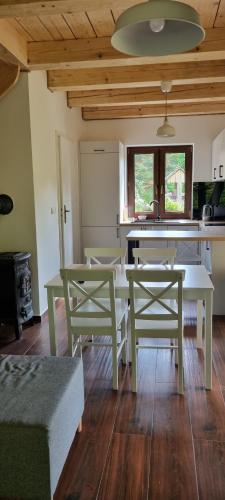 a living room with a table and chairs and a kitchen at Leśniczówka Kalina in Wetlina