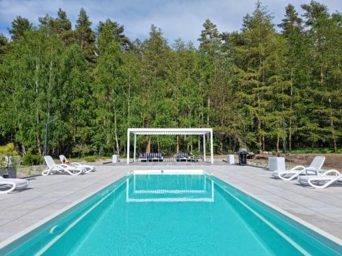a swimming pool with chairs and a gazebo at NOVA ULINIA Forest in Ulinia