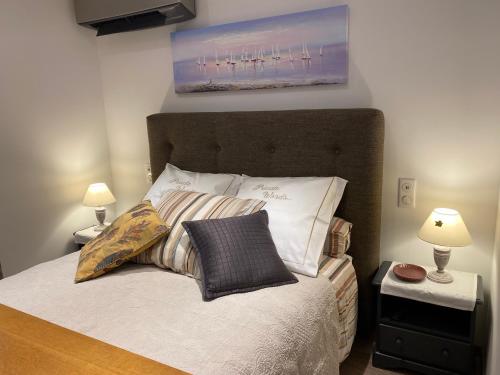 a bedroom with a bed with pillows and two lamps at Little Bohême, luxe, piscine, SPA, tout à pied, Port Grimaud in Grimaud