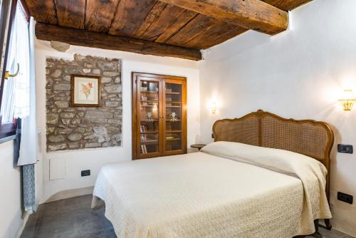 1 dormitorio con cama y pared de piedra en Nearby 5Terre Authentic Apartment, en Carrodano Inferiore