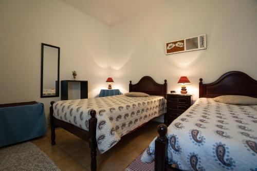 ポンタ・デルガダにあるConforto Citadinoのベッドルーム1室(ベッド2台、鏡付)