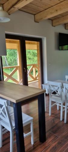a dining room with a table and white chairs at Leśniczówka Kalina in Wetlina