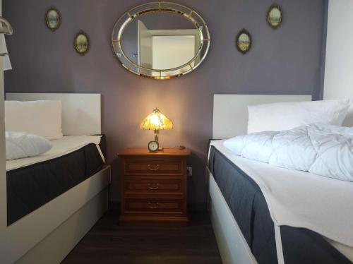 ein Schlafzimmer mit 2 Betten und einer Lampe auf einem Nachttisch in der Unterkunft Ferienwohnung Schüler-Wolke 2 in Sankt Andreasberg