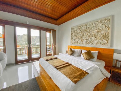 a bedroom with a large bed with a painting on the wall at Villa Danu in Kintamani
