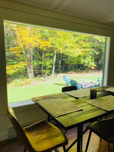 a table and chairs in a room with a large window at The Cabin @ Benton Hollow in Livingston Manor