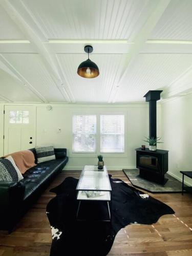 a living room with a black couch and a stove at The Cabin @ Benton Hollow in Livingston Manor
