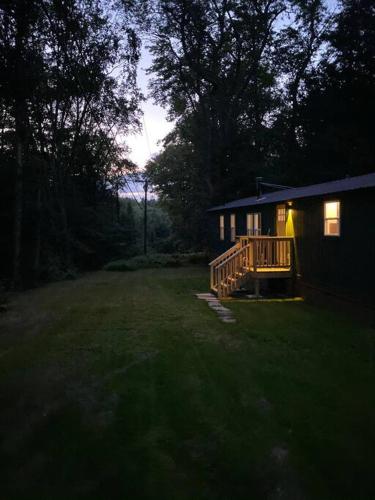 a house with a porch and a deck in a yard at The Cabin @ Benton Hollow in Livingston Manor