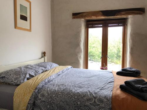 a bedroom with a bed and a window with a view at Teach Talamh in Kinvara