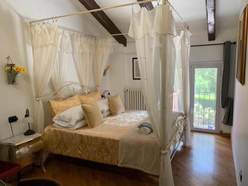 a bedroom with a canopy bed with white curtains at La Casa Celeste B&B in Asti
