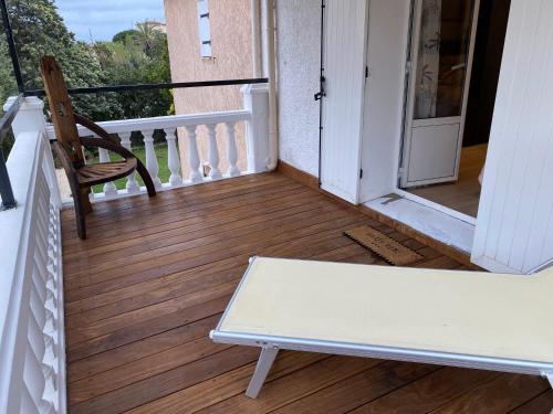 a porch with a chair and a bench on a balcony at Little Bohême, luxe, piscine, SPA, tout à pied, Port Grimaud in Grimaud