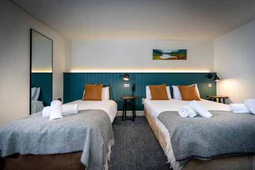 a hotel room with two beds and a mirror at Loch Ness Inn in Drumnadrochit
