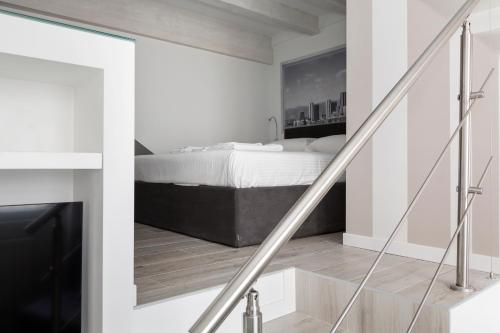 een witte slaapkamer met een bed en een trap bij Nest for 2 in Milan Fashion District in Milaan