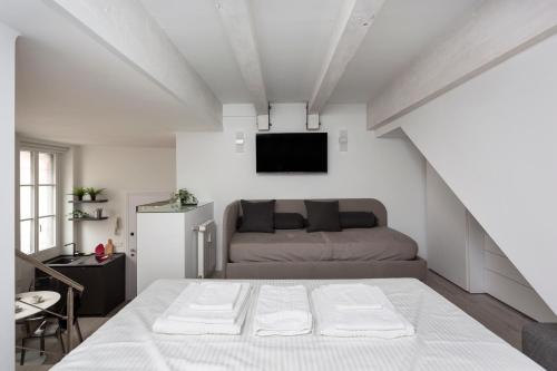 een slaapkamer met een bed en een tv aan de muur bij Nest for 2 in Milan Fashion District in Milaan