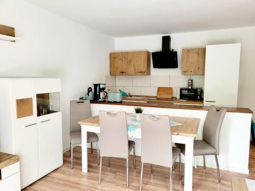 a kitchen with a wooden table and white chairs at Exklusivwohnung Nempitz in Nempitz