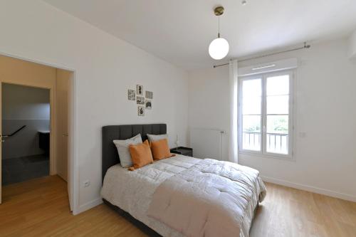 a white bedroom with a bed and a window at Résidence Montana Clamart in Clamart