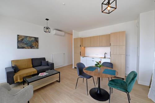 un salon avec un canapé, une table et des chaises dans l'établissement Résidence Montana Clamart, à Clamart