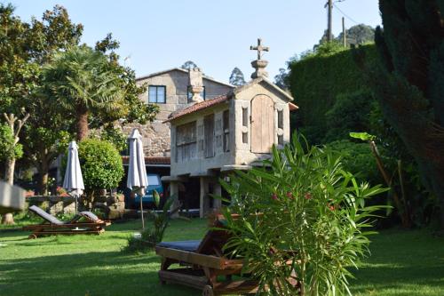 un jardin avec une petite maison en herbe dans l'établissement Casa Videira - Hotel rural cerca del mar, à Bueu