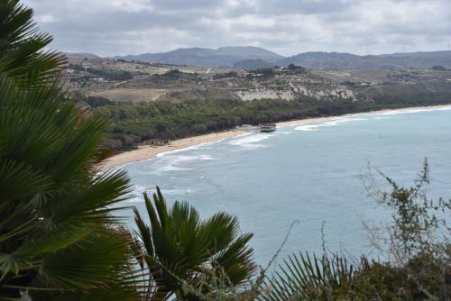 a view of a beach with a boat in the water at La valle degli dei in Eraclea Minoa
