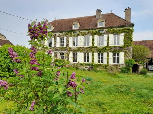 an old house with flowers in front of it at Maravillon - Chambres d'hôtes in Villon