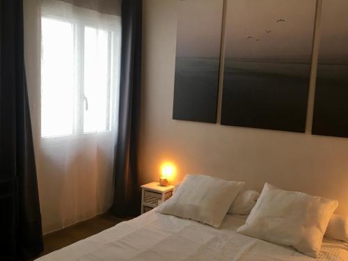 - une chambre avec un lit doté d'une fenêtre et d'une lampe dans l'établissement MISSIAMINAGE, à La Rochelle
