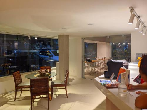 a living room with a table and chairs and a kitchen at Hotel Saveiro in Recife