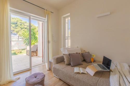 ein Wohnzimmer mit einem Sofa und einem Laptop darauf in der Unterkunft Villa Agave al mare in Specchiolla 
