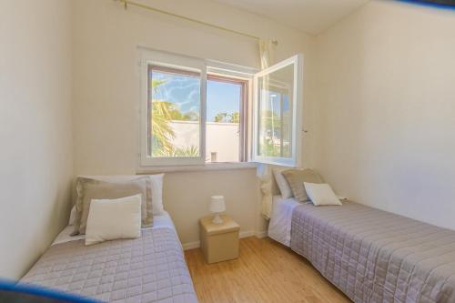 a bedroom with two beds and a window at Villa Agave al mare in Specchiolla 