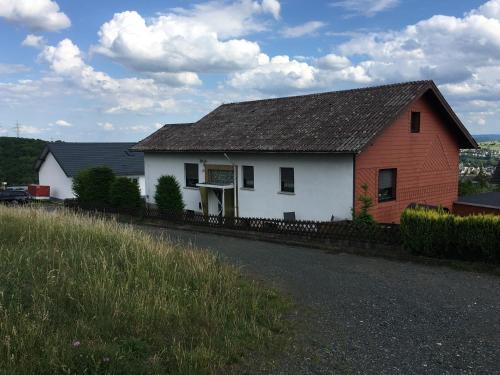 a white house and a red and white barn at Haus Willi in Aßlar